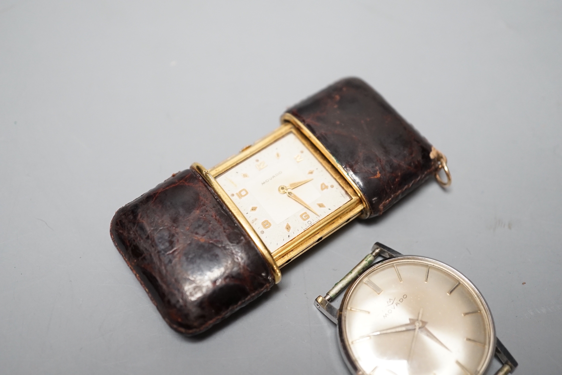 A Movado leather mounted gilt metal travelling timepiece, 49mm and a stainless steel Movado manual wind wrist watch(lacking winding crown).